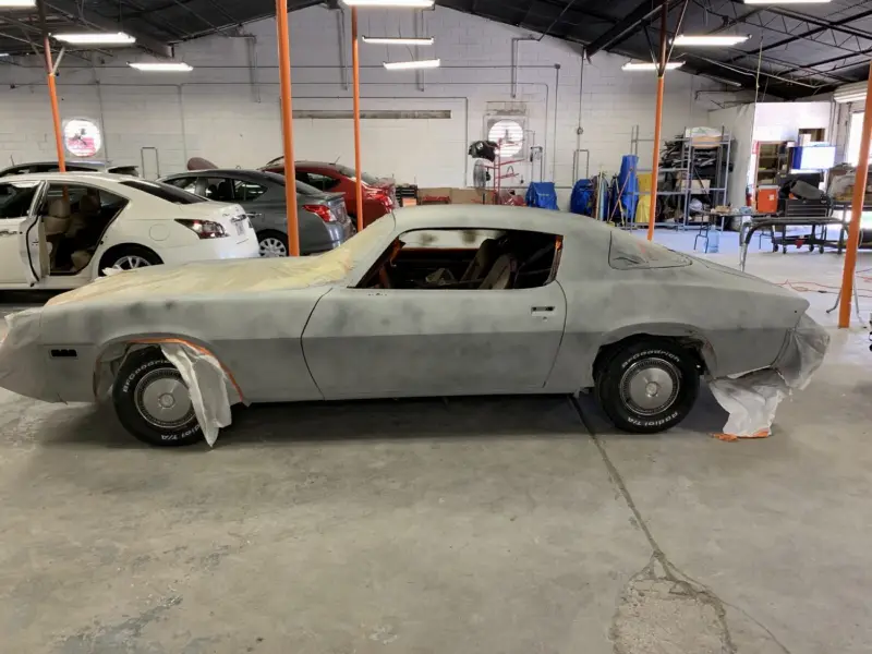 Classic car in primer being prepped for paint at McCoy Enterprises