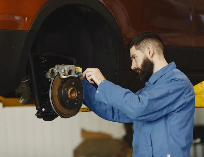 Mechanic replacing car brake pads and rotor